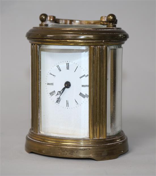 An Edwardian miniature brass carriage timepiece with oval case 8cm